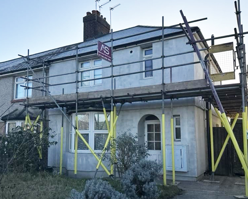 About Armstrong Scaffolding Armstrong Scaffolding erected around a brick building in Kent with workers in high-vis vests