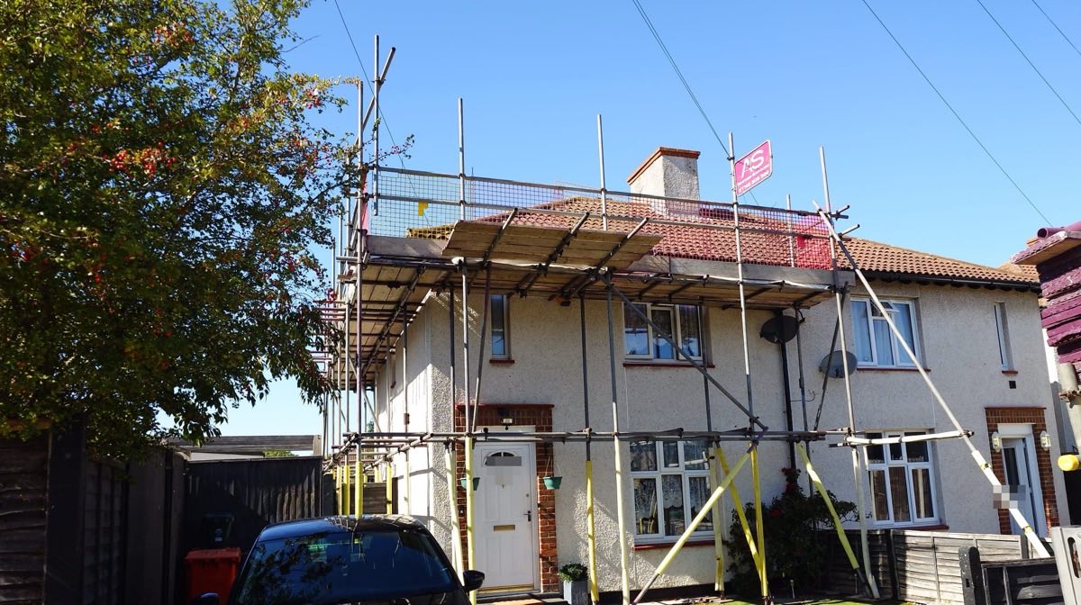 Roofing Scaffold Across Twenty Identical Houses, West London - Armstrong Scaffolding Boarded scaffold lift at eaves level across a house in west London, one of twenty on the same contract